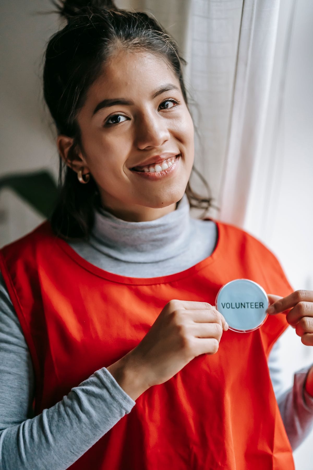 Voluntaria sonriente con chaleco rojo